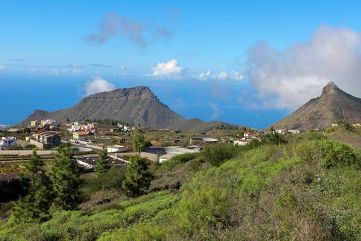 Landscape with green plants in the front, houses and mountains in background on Canary Island Tenerife