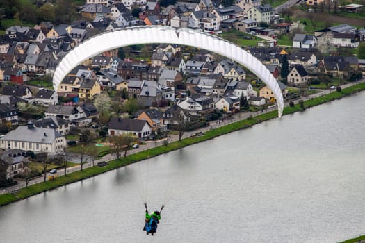 Flying paraglider over the valley of river Moselle and over vineyards