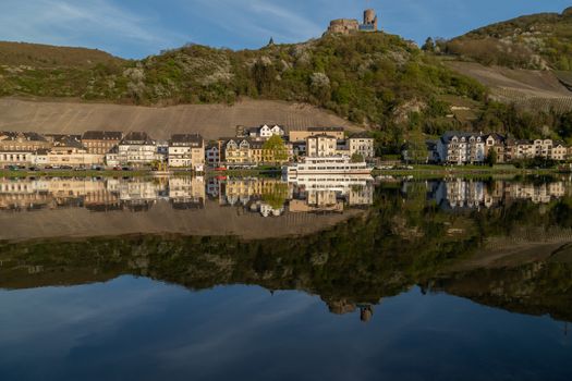 View at the city of Bernkastel-Kues at river Moselle with passenger ships and mountains with vineyards in the background