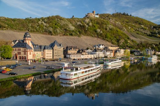 View at the city of Bernkastel-Kues at river Moselle with passenger ships and mountains with vineyards in the background