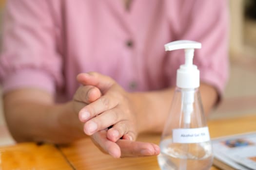 Close Up Asian woman using hand sanitizer by pumping alcohol gel 75% for prevent coronavirus or covid 19.