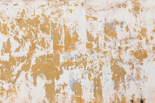 Shabby flat plaster and painted wall with big yellow under layer spots.