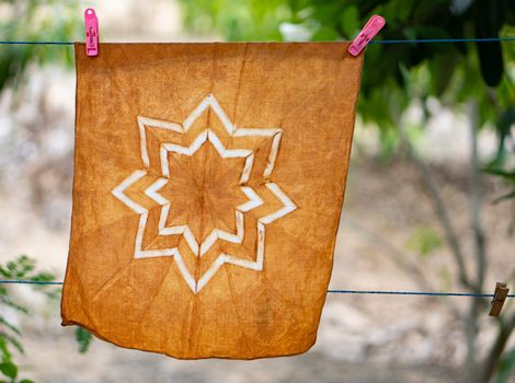 Hand-dyed batik cloth hanging in the outdoor garden.