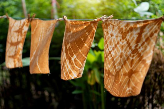 Hand-dyed batik cloth hanging in the outdoor garden.