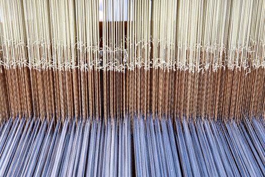 Close up of a lot of threads in a weaving machine called a loom