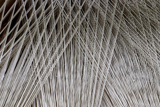 Close up of a lot of threads in a weaving machine called a loom