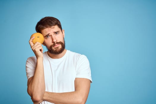 man with orange on blue background and cropped view Copy Space gesturing with hands. High quality photo