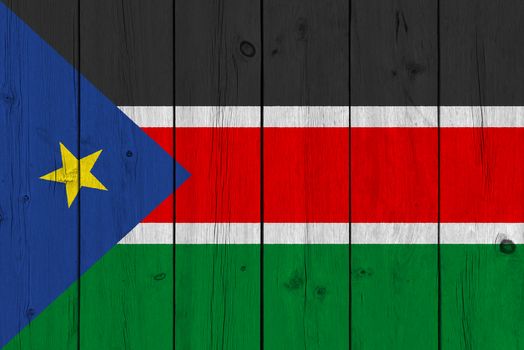 South Sudan flag painted on old wood plank. Patriotic background. National flag of South Sudan