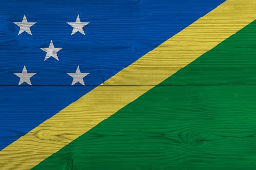 Solomon Islands flag painted on old wood plank. Patriotic background. National flag of Solomon Islands