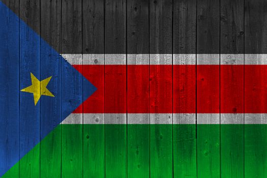 South Sudan flag painted on old wood plank. Patriotic background. National flag of South Sudan