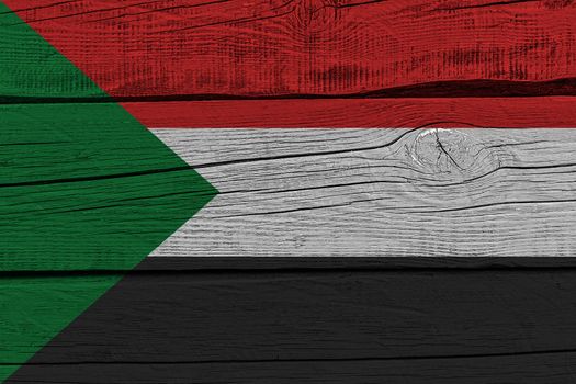Sudan flag painted on old wood plank. Patriotic background. National flag of Sudan