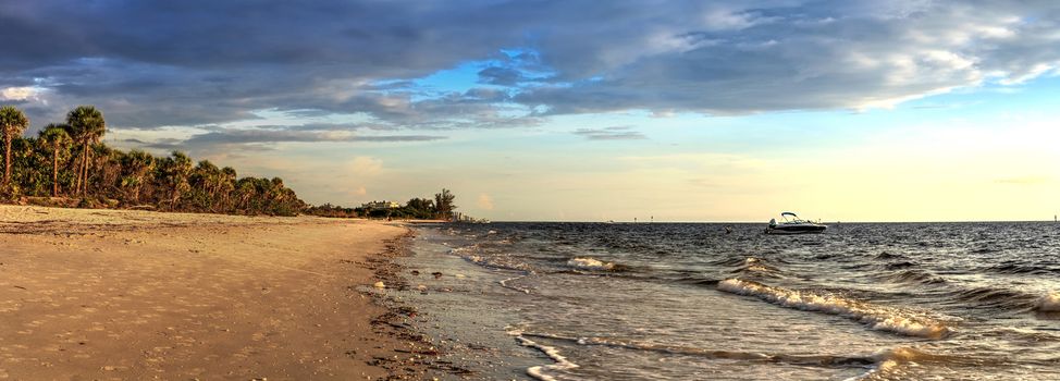 Boat on the waters off Barefoot Beach under dark skies in Bonita Springs, Florida