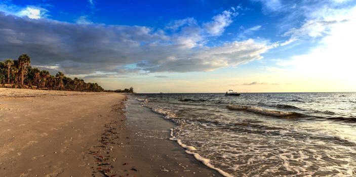 Boat on the waters off Barefoot Beach under dark skies in Bonita Springs, Florida