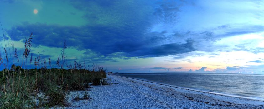 Moonrise over the dark sky over Barefoot Beach in Bonita Springs, Florida