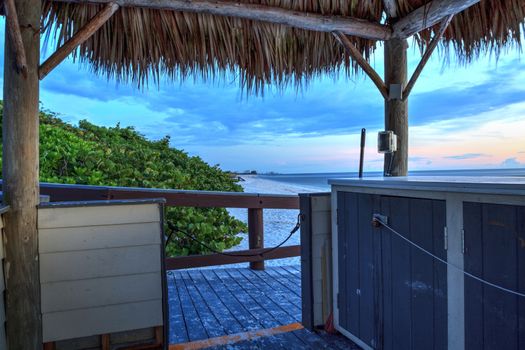 Tiki hut Boardwalk leads down to the white sand of Barefoot Beach in Bonita Springs, Florida