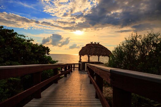 Tiki hut Boardwalk leads down to the white sand of Barefoot Beach in Bonita Springs, Florida
