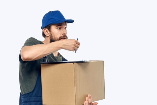 Working male courier with box in hand documents delivery service light background. High quality photo