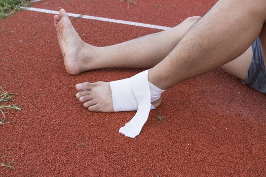 man applying compression bandage onto ankle injury After exercise concept Sports injuries.
