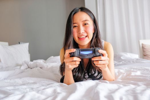 Beautiful girl playing video game on bed