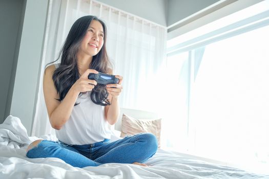 Beautiful girl playing video game on bed