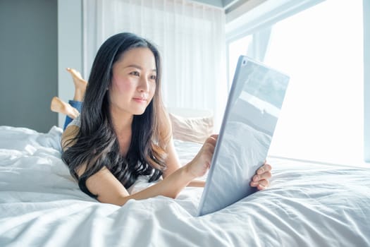 Yound woman using tablet on the bed 