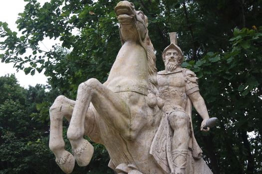 Statue made of white stone marble of an ancient famous soldier riding on the horse- White marble statue of an ancient man holding a scroll and riding a horse