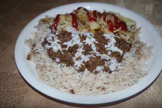 Delicious traditional dish of rice with potato fries and cereals with red ketchup. Food background with copy space for text and advertisements.