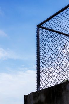 Old of mesh fence with the blue sky.