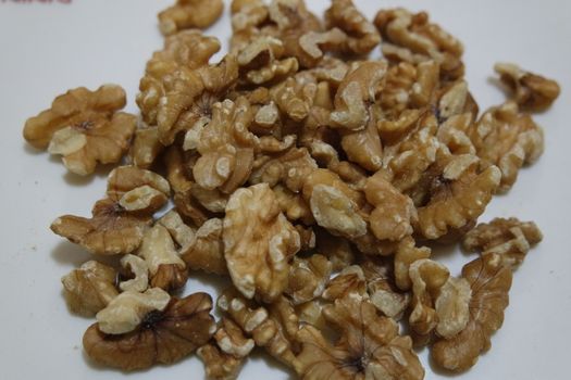 Close-up top view of peeled walnut on a white background. peeled walnut without shell ready to eat dry fruit.