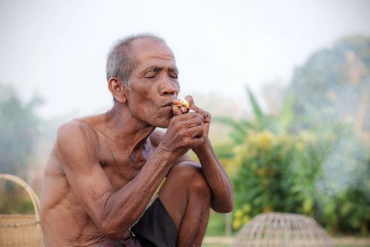 Older people are smoking in the countryside.