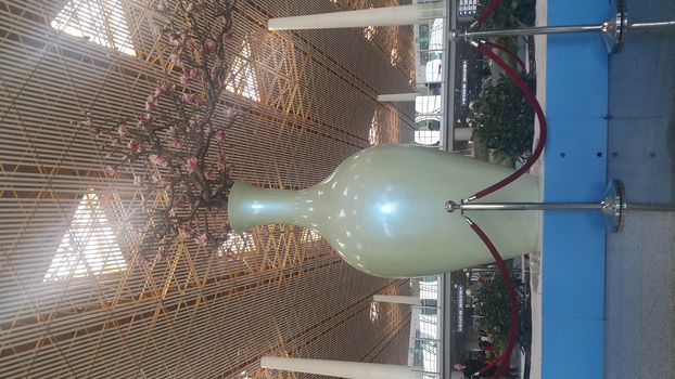 Beautiful view of a huge flower vase with beautiful flowers placed in a big hall skyscraper building