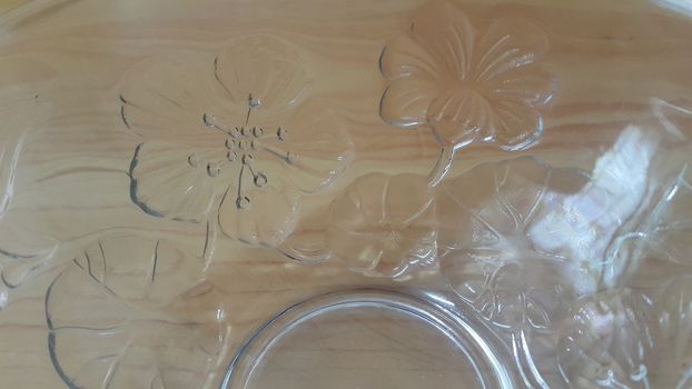 Top view of empty white glass bowls on a wooden floor. Glass bowl with flowers made on its wall