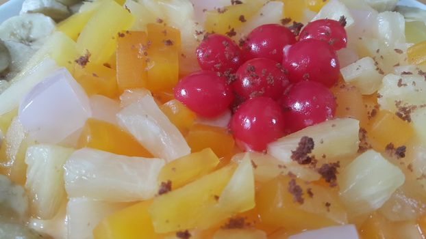 Creamy tasty sweet fruit trifle over custard with banana slices layered on surface. A top view of home made fruit trifle, a products for dessert after meal.