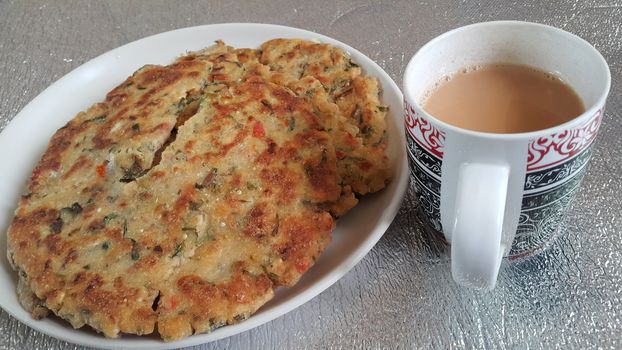 Closeup view of of traditional bread called Jawar roti or bhakri with tea cup. Bhakri is a round flat unleavened bread often used in the cuisine of many Asian countries