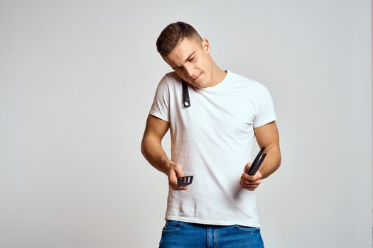 Guy with kitchen tools in hands on a light background cropped view of emotions fun model. High quality photo