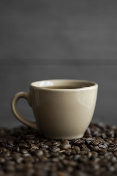 Cup of coffee with roasted coffee beans background. Mug of black coffee