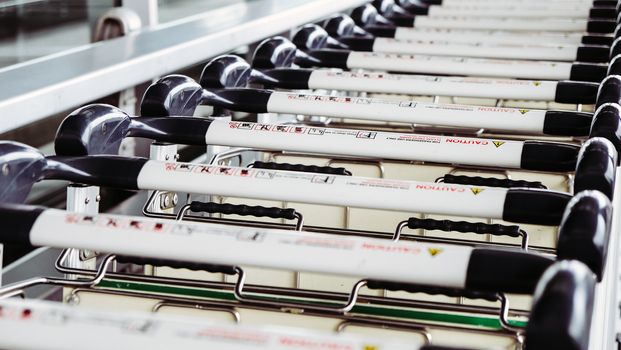 Image of Luggage trolley in a row at the airport