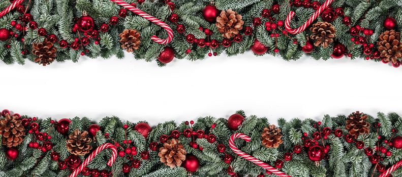 Christmas border frame design copmosition of noble fir tree branch and red decorations balls baubles berries pine cones isolated on white background