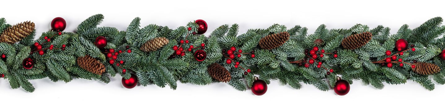 Christmas border frame stripe design copmosition of noble fir tree branch and red decorations balls baubles berries cones isolated on white background