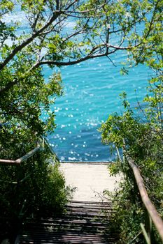 Steps to the sea shore with azure water.