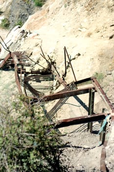 An old ruined metal staircase in the cliff leading to the sea beach.