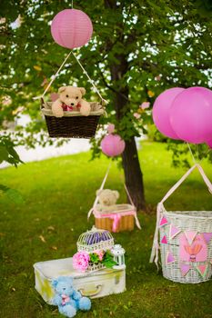 street decorations for a children's party. Wicker baskets with balloons in a green park.