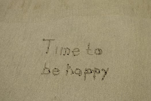 Close-up Of Time To Be Happy Text And Smile Written On Sand At Beach.