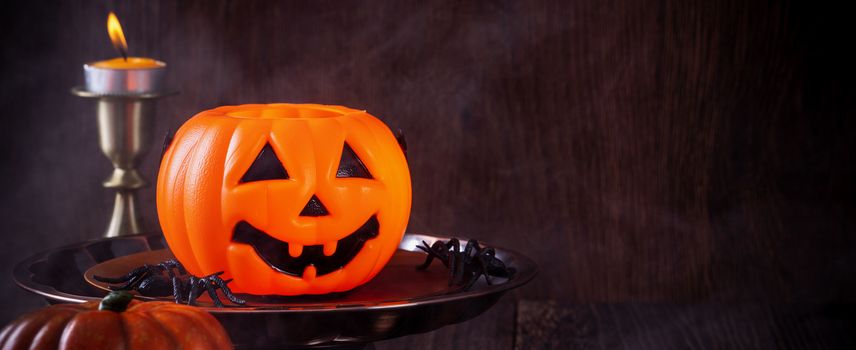 Spooky Halloween decor, horror festival concept, pumpkin lantern with candlestick.