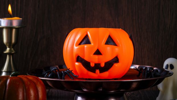 Spooky Halloween decor, horror festival concept, pumpkin lantern with candlestick.