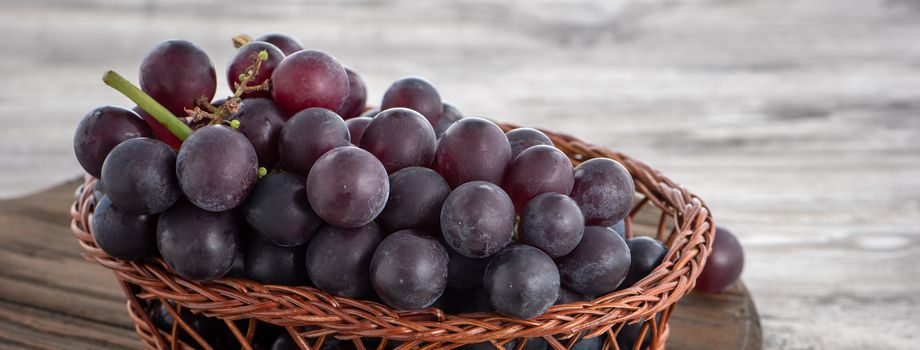 Delicious bunch of grapes fruit on a plate over wooden table background.