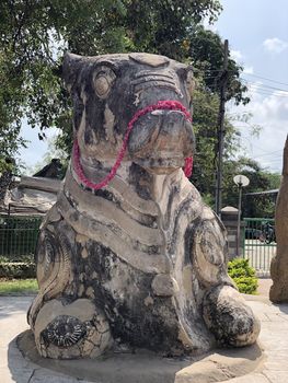 Bull mammal sculpture kept for worship in ancient Hindu temple with decorations.