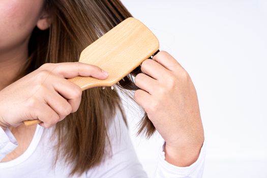Closeup on young woman combing her hair. Daily life concept.