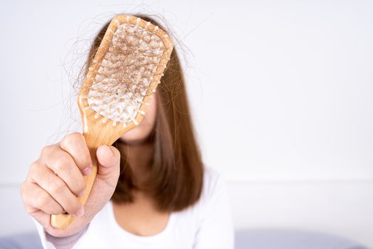 Hair fall problem, closeup hand holding comb and problem hair. Healthcare medical or daily life concept.