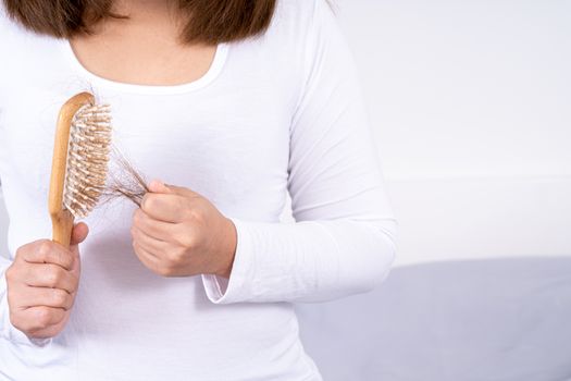 Hair fall problem, closeup hand holding comb and problem hair. Healthcare medical or daily life concept.